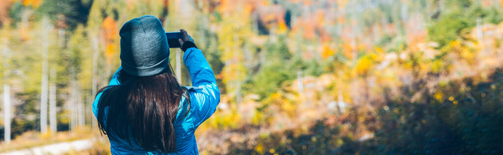 Woman Taking Photo with Smartphone while on a Hike