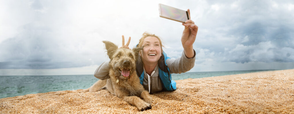 woman taking selfie with dog using Google Pixel smartphone