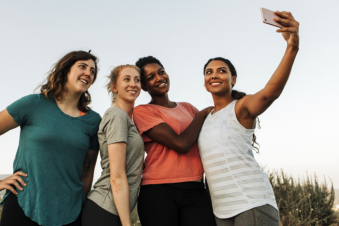 friends taking selfie outside while hiking