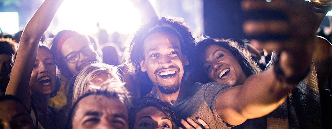 man taking selfie at concert