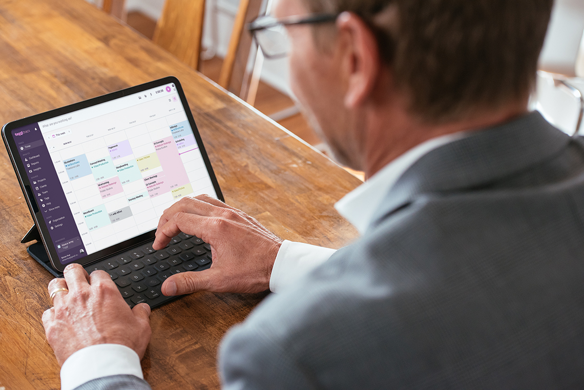 man using Toggl app from tablet while working from home - work from home tech