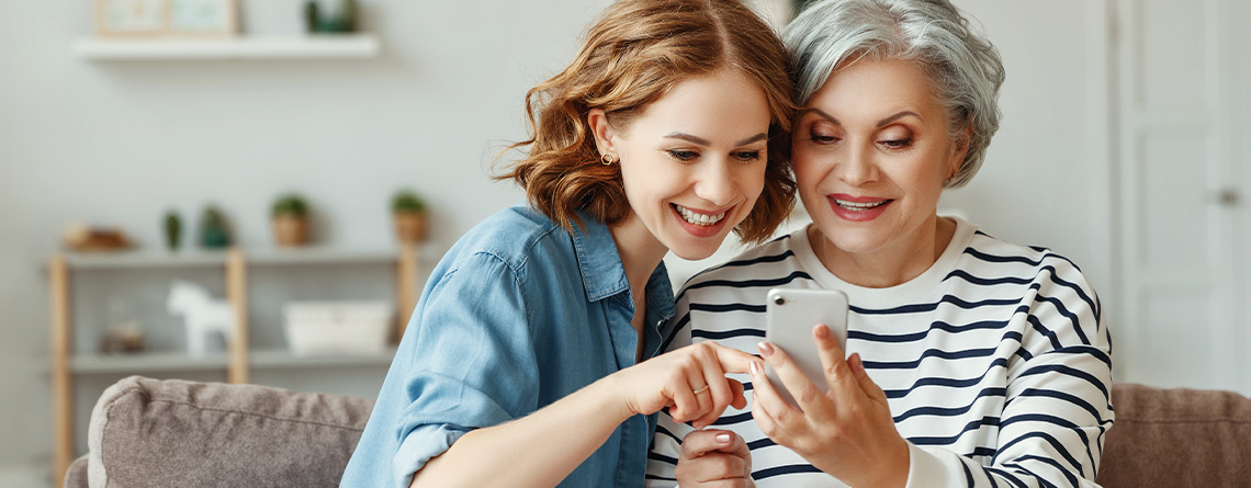 Adult daughter showing mother something on her Verizon smartphone