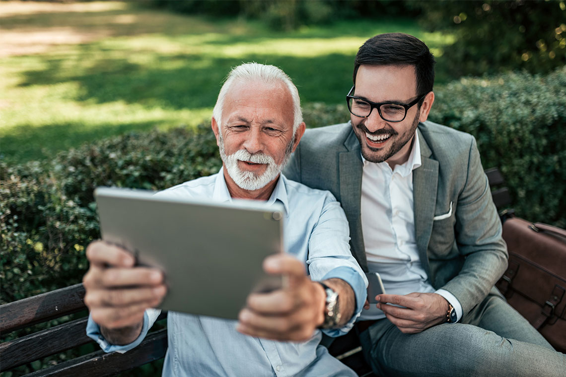 Dad and son outside at park look at Apple iPad on Father's Day 2021