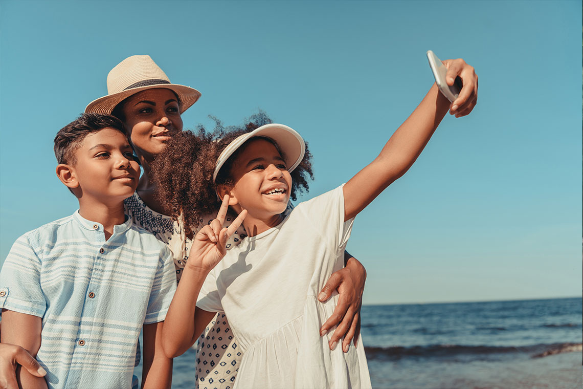 family taking selfie at beach