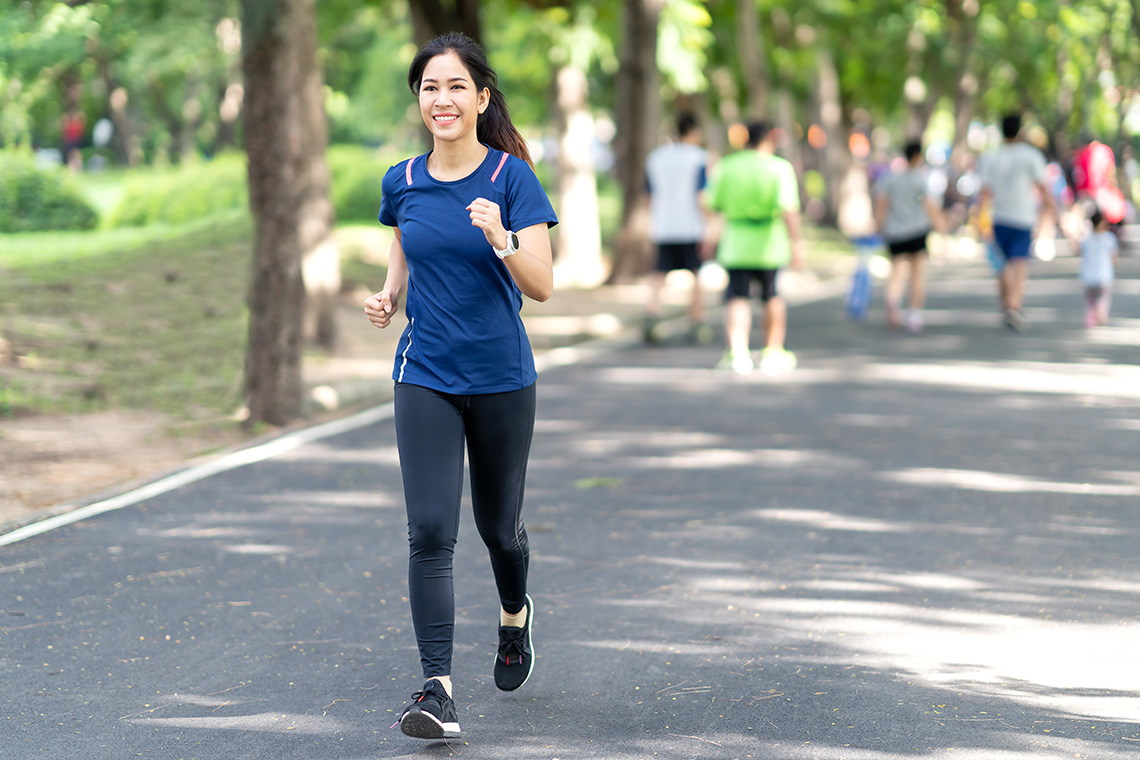 female college student jogging in a park