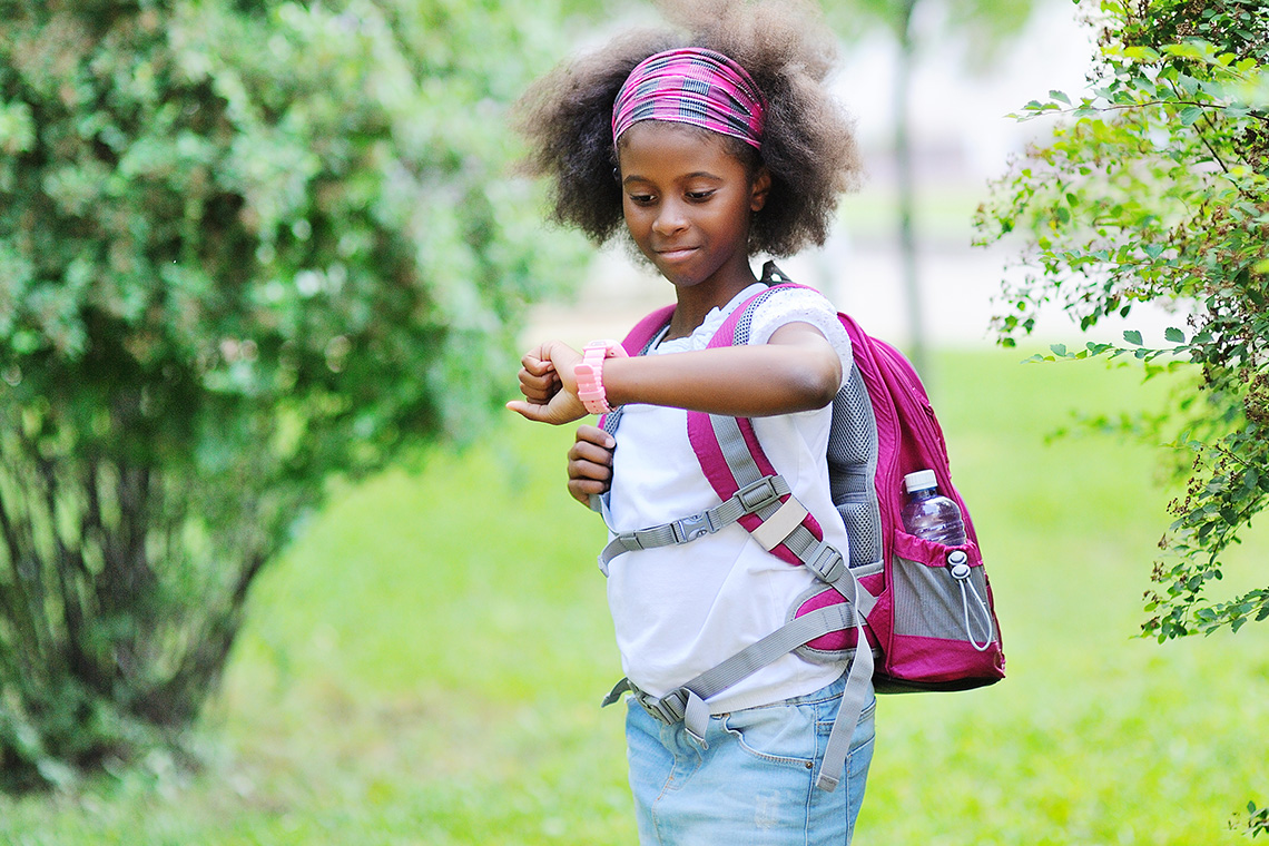 female student with backpack checking Verizon gizmowatch