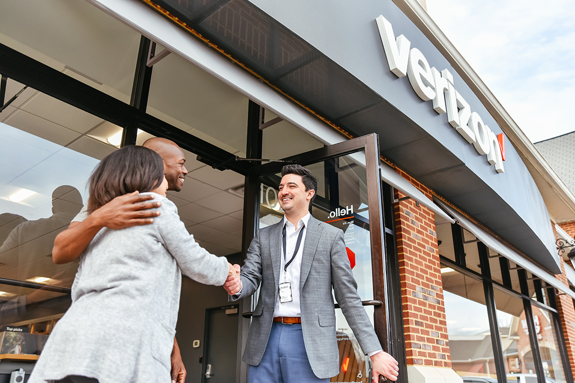 Cellular Sales wireless consultant welcoming customers into Verizon store