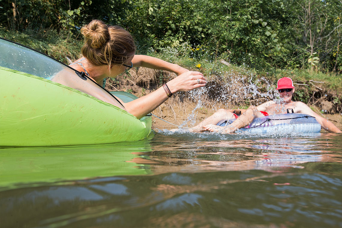 people on river tubes and splashing each other