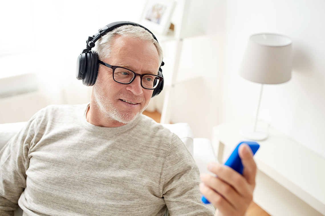 older man learning how to start a podcast with smartphone