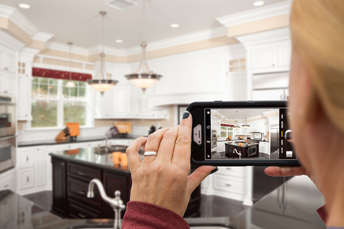 realtor takes real estate photos of kitchen with a smartphone