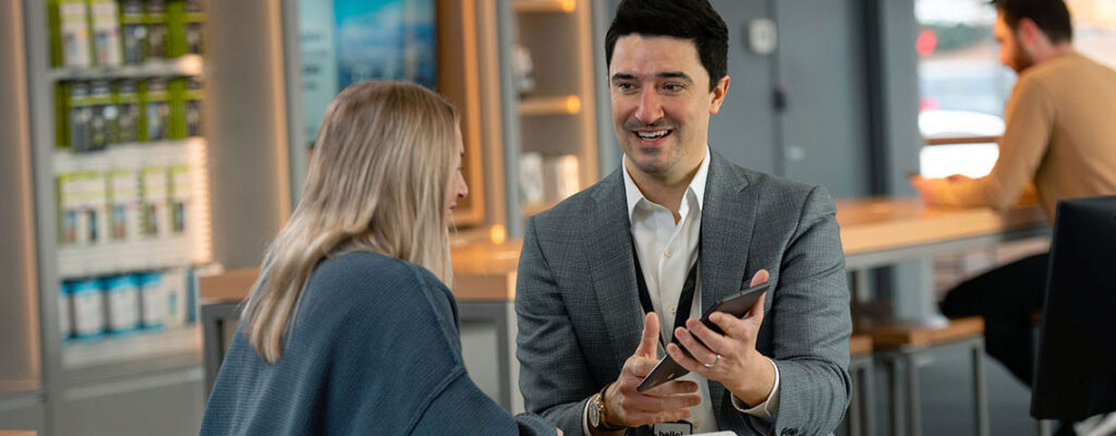 cellular sales wireless sales consultant helping woman in store shopping for a new smartphone