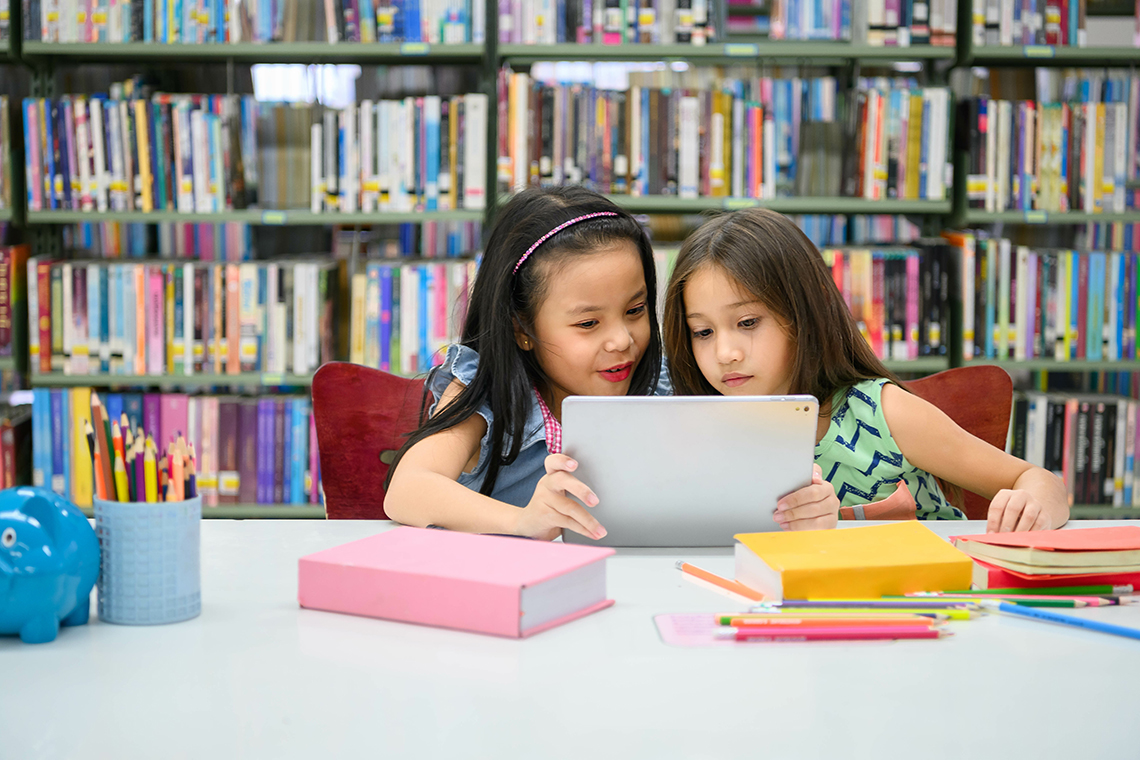 two students in library using tablet