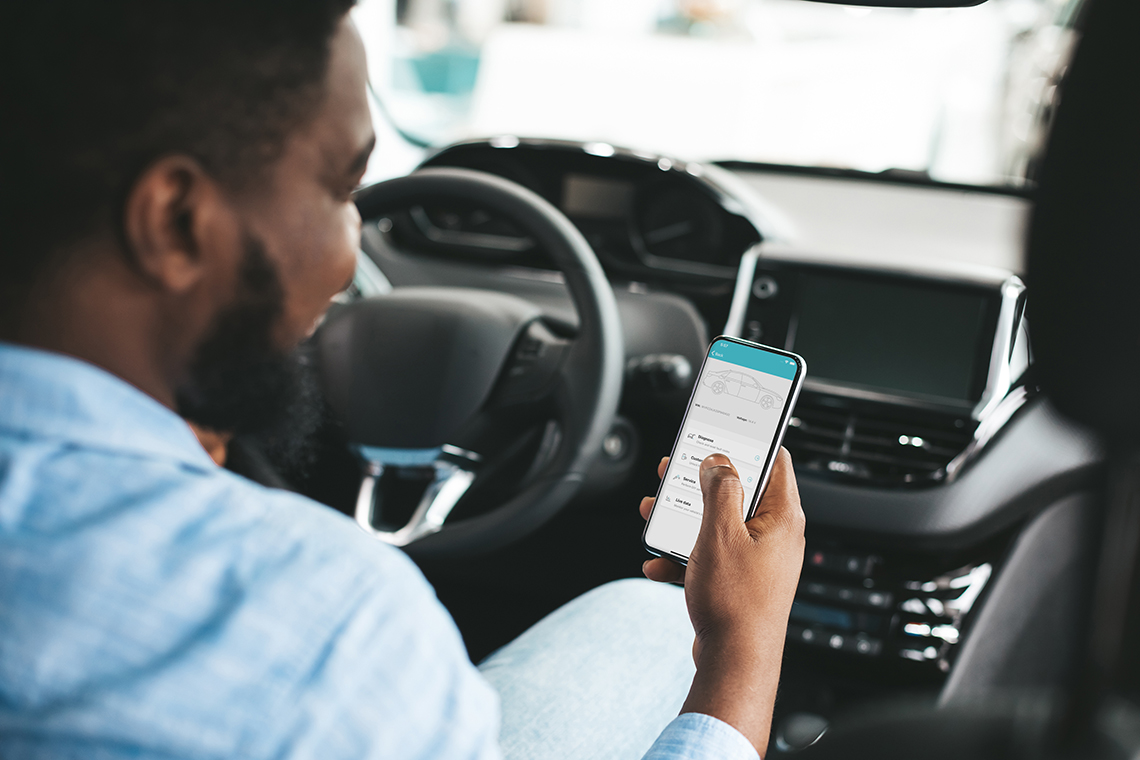 man checking car diagnostic app in car