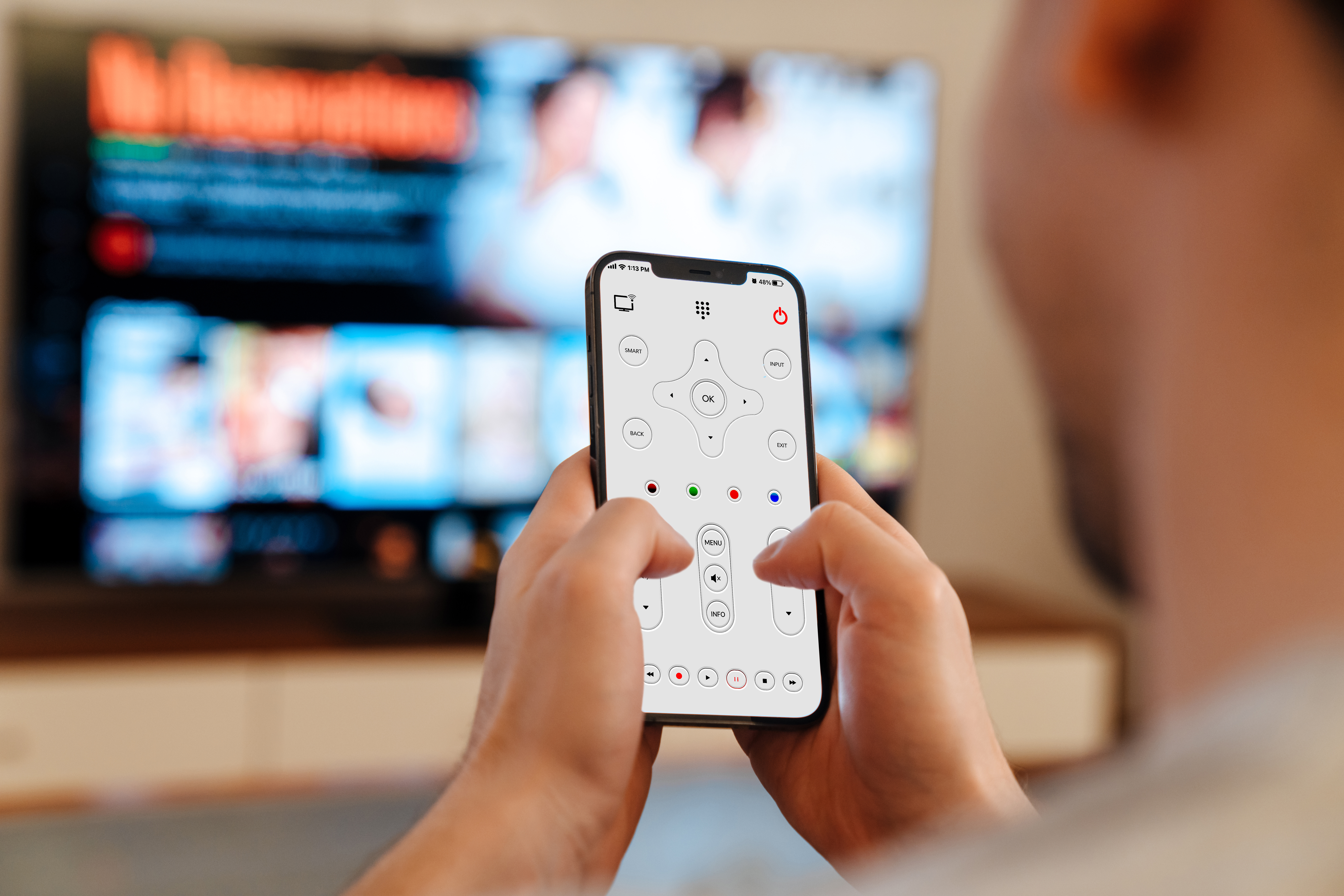 person using universal remote app on smartphone