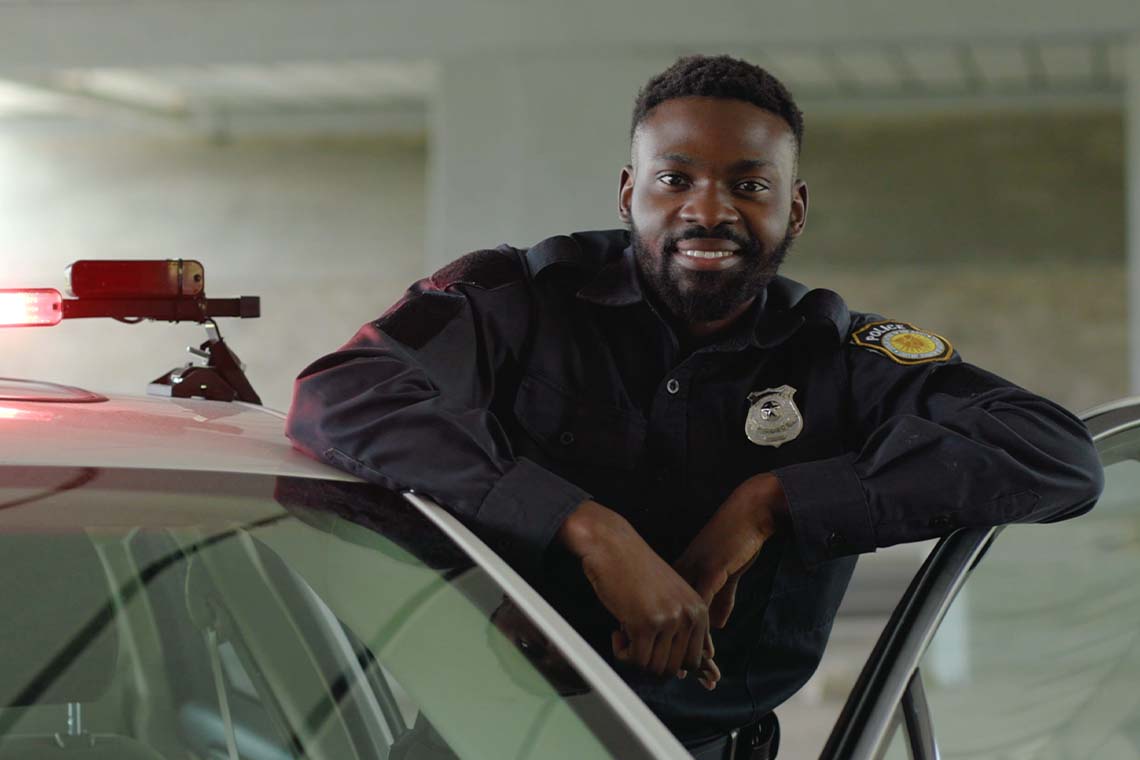 police officer standing inside open door of police car