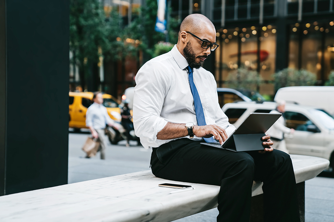 business man using mobile hotspot to work outside