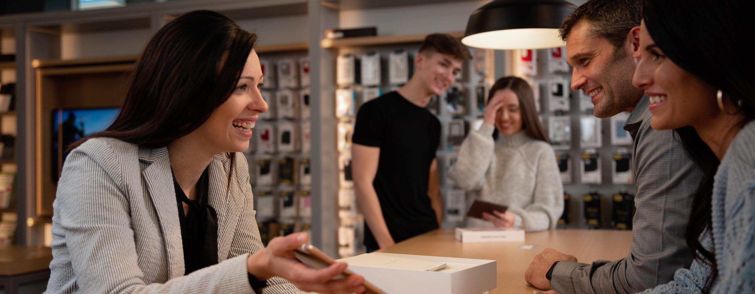 Verizon Sales Consultant helping couple in Cellular Sales Verizon store