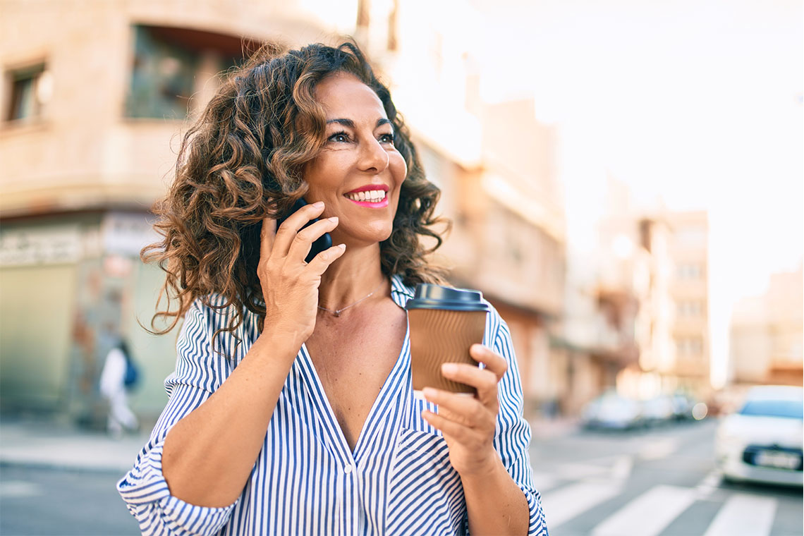 senior woman using smartphone outside in city