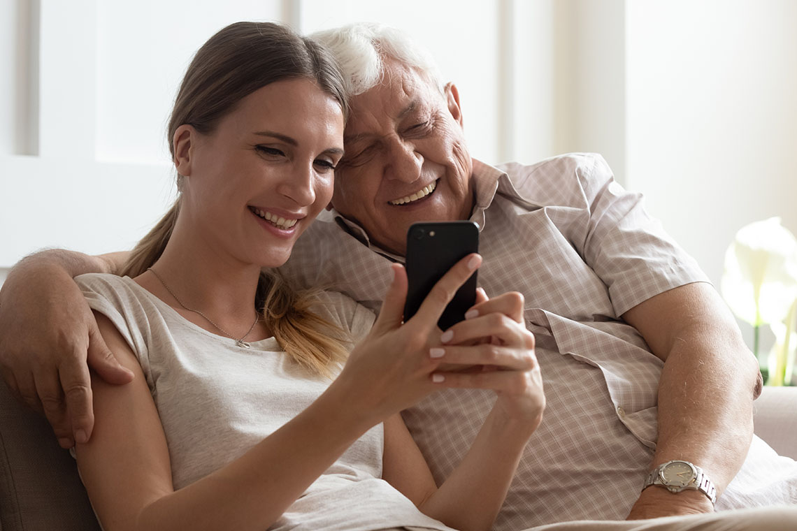 granddaughter and grandfather looking at smartphone