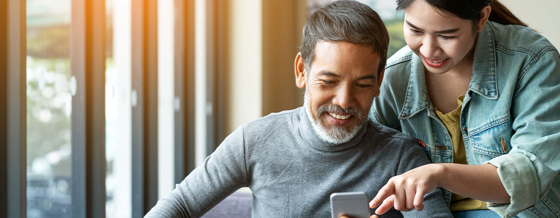 senior father and daughter using smartphone