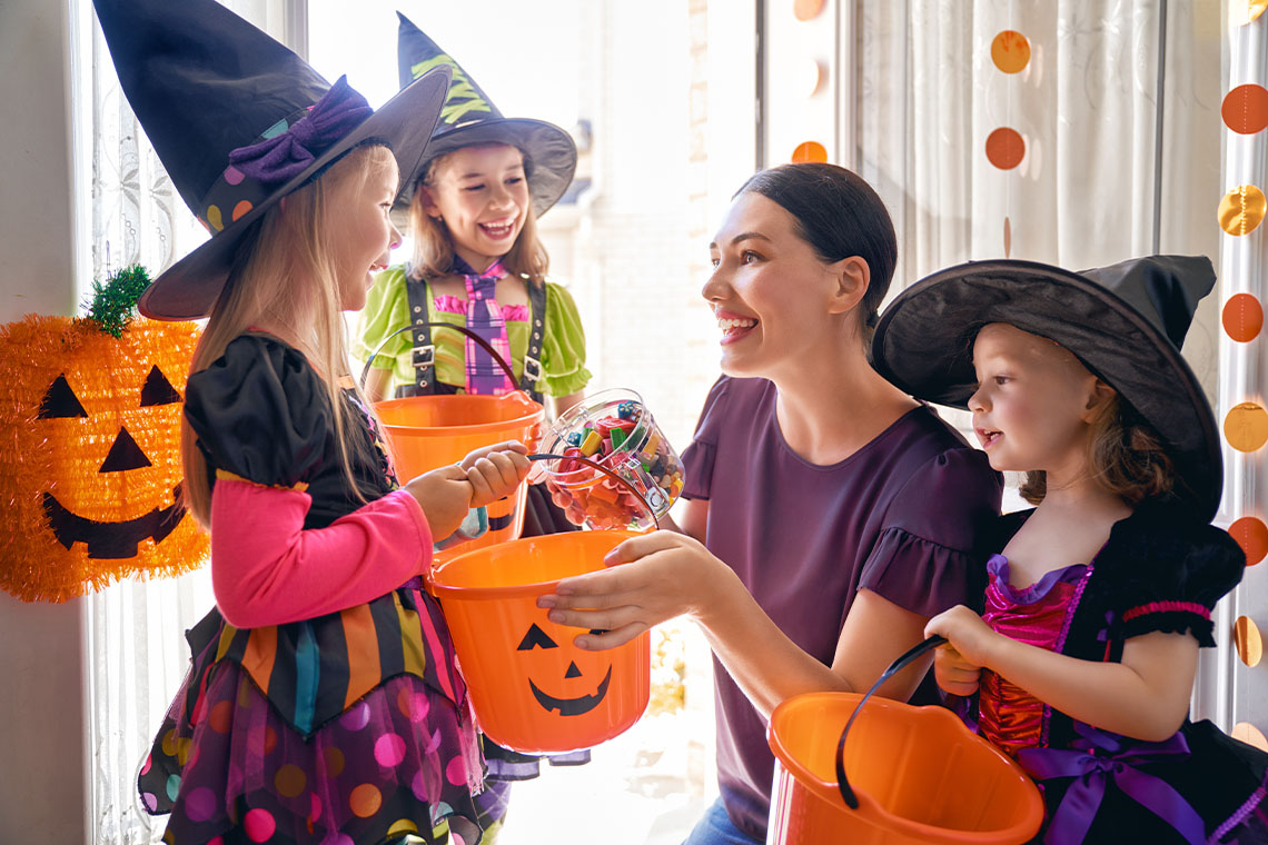 mother getting kids ready to go trick or treating for halloween 2021