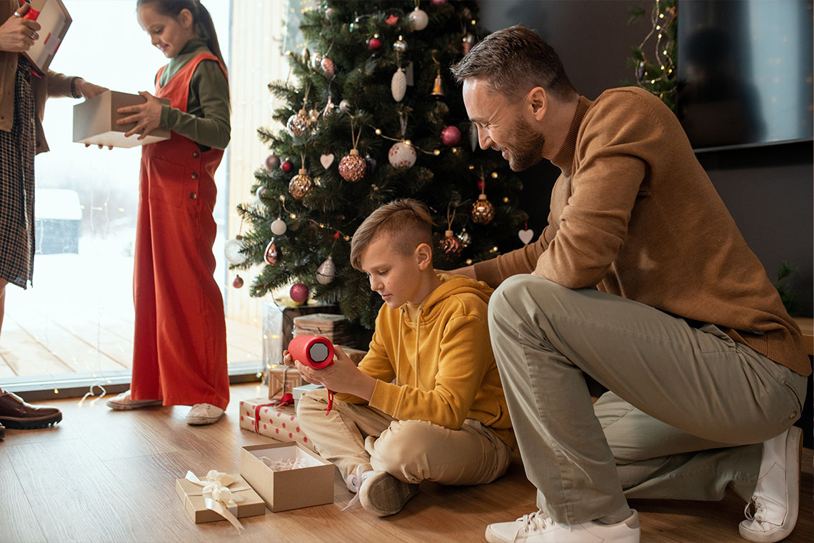 father and son opening up jbl flip 5 bluetooth speaker on christmas