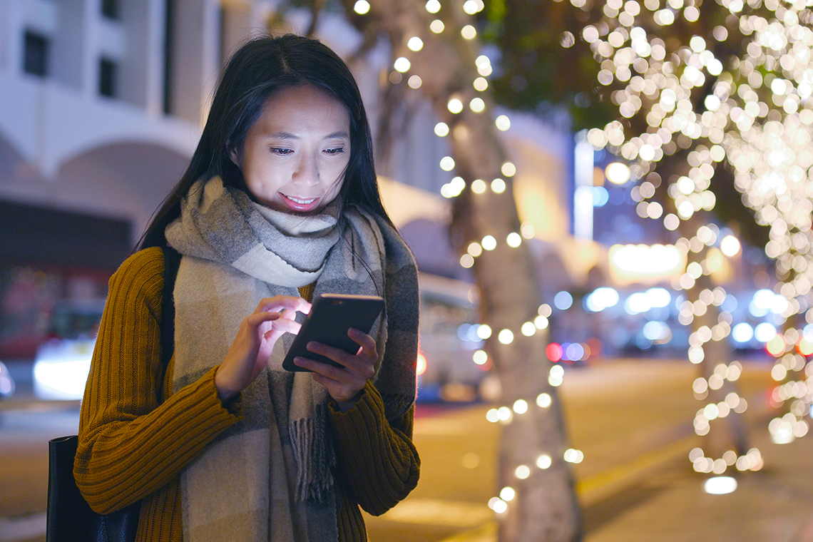 woman checking smartphone outside using 5G network