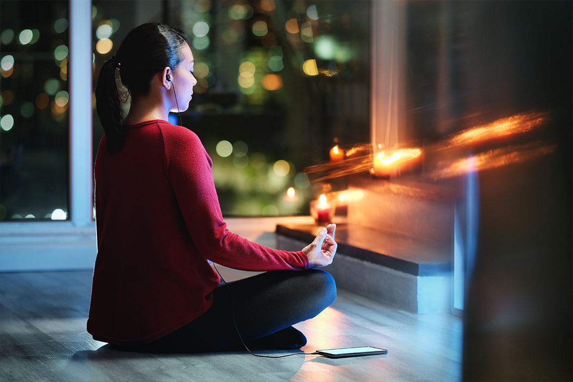 woman meditating using smartphone app