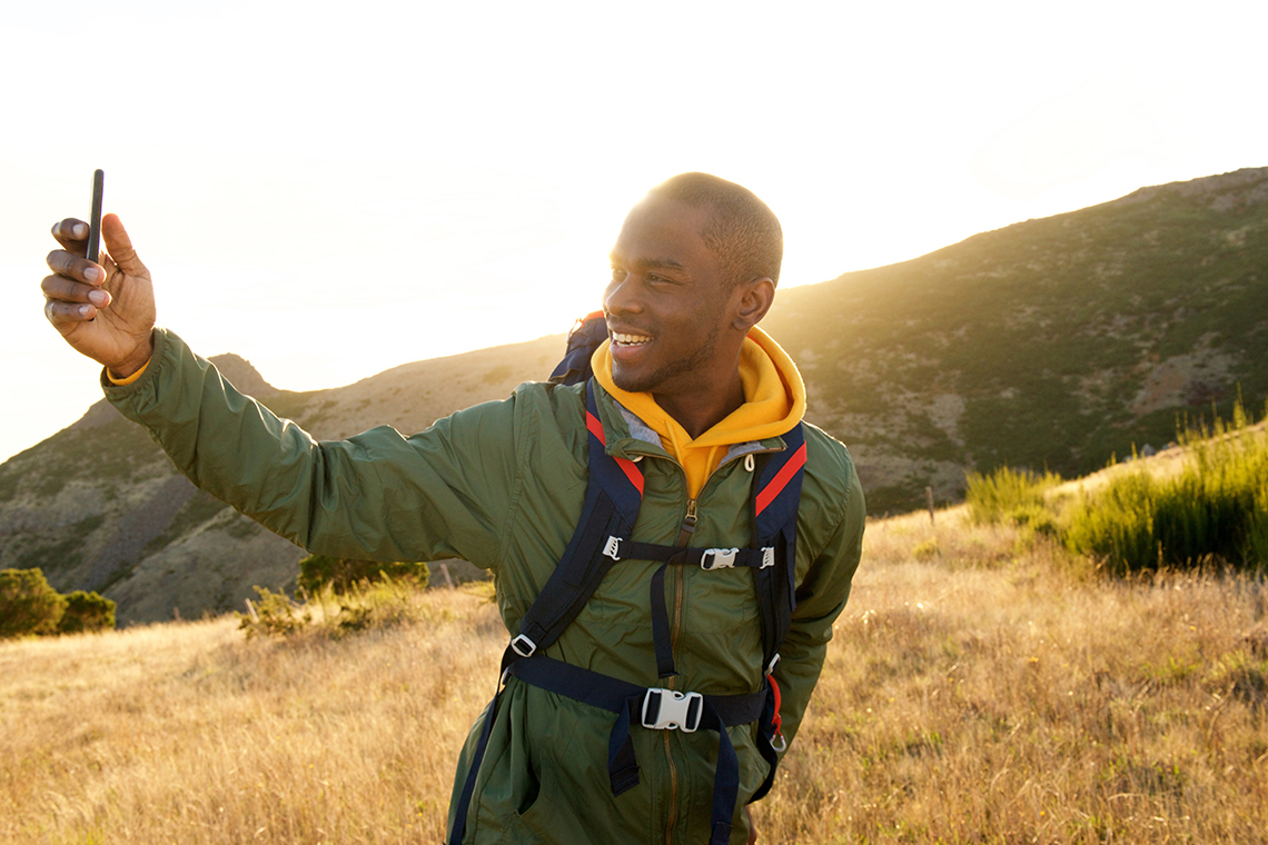 man in hiking gear taking selfie outside