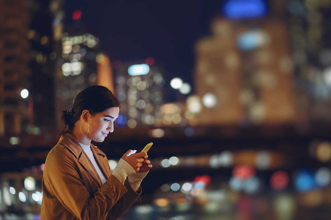 woman checking smartphone with 5G Ultra wideband