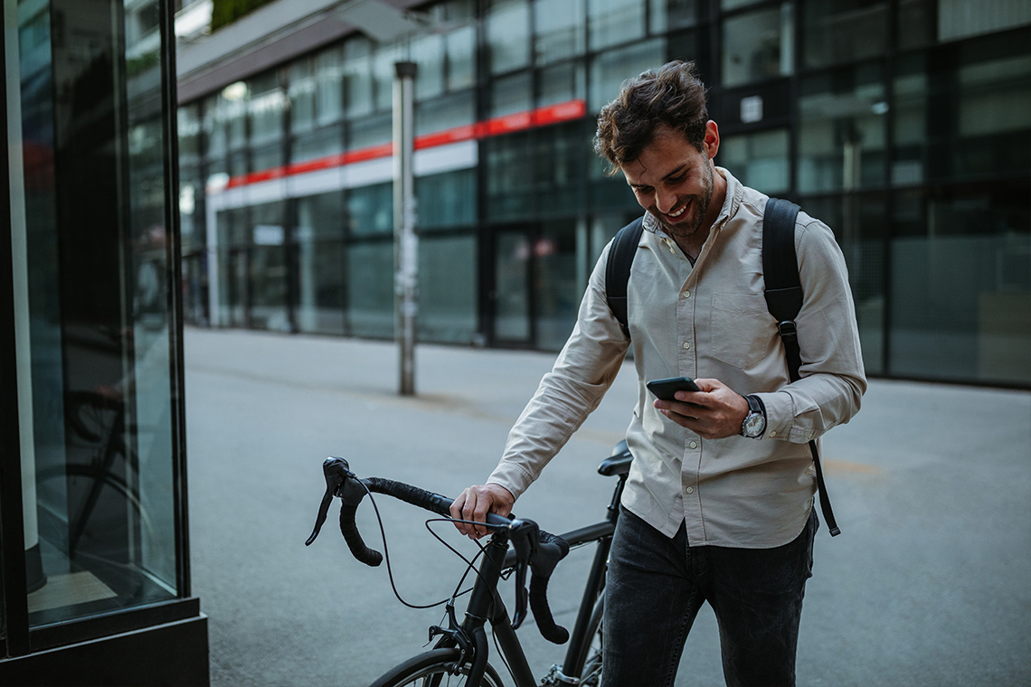 man with bicycle looking at 5G smartphone
