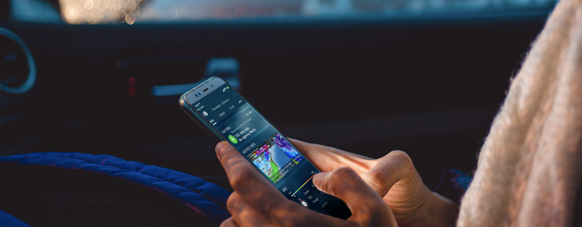 A smartphone held in a person's hands displays a weather preparedness app.