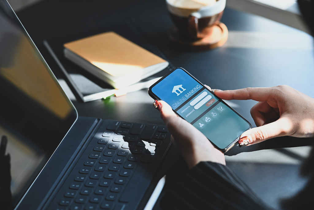 Two hands hold a smartphone displaying a banking app login screen.
