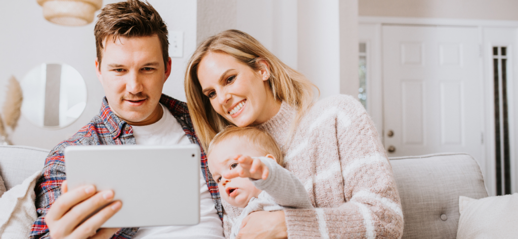 couple with baby looking at tablet