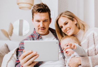 couple with baby looking at tablet