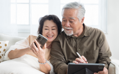 elderly couple cuddling with phone and tablet