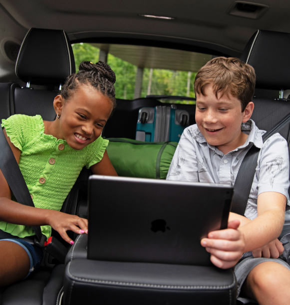 kids looking at tablet in car