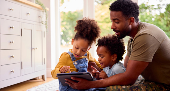 father with kids on tablet