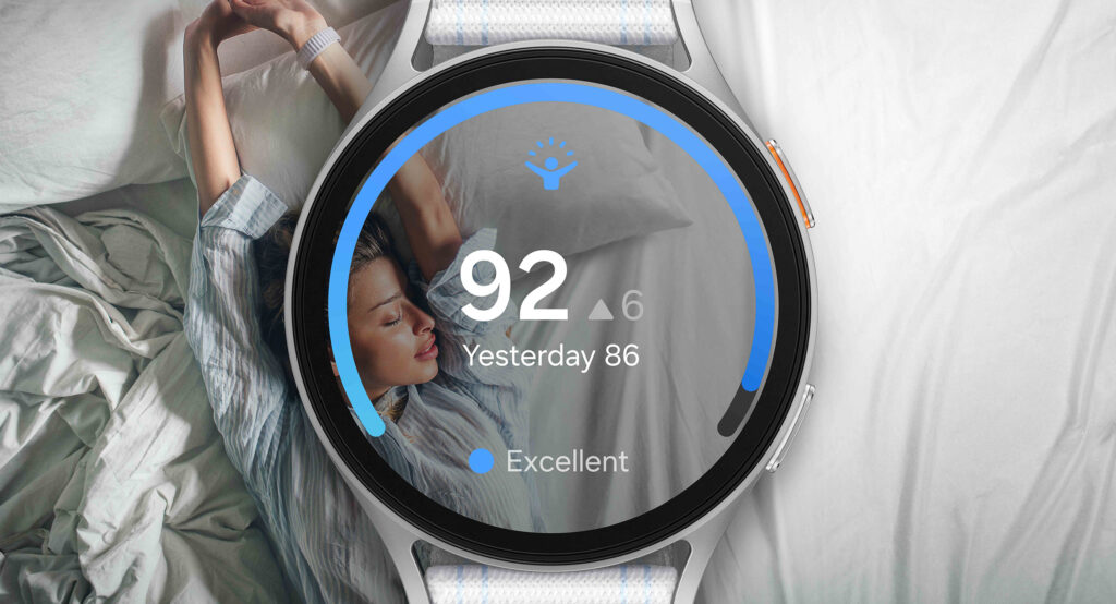 Samsung Galaxy Watch7 face over an image of a woman asleep in a bed. She is overlayed by an Energy Score of 92. The score is surrounded by a black circle with a partial blue circle inside.